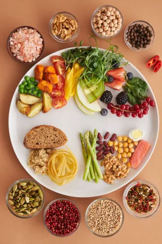 Assiette équilibrée vue de dessus : légumes, fruits, féculents, protéines, oléagineux